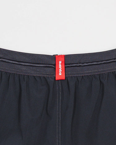Back waistband of the Equipe Motion Men’s Shorts in grey, featuring a red woven Equipe label and reinforced stitching on lightweight performance fabric.