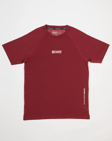 Equipe Motion Men’s Tee in maroon with Gracie Barra stacked wordmark on the chest, Legacy G and performance slogan on the side, moisture-wicking construction on a white background.