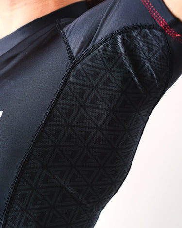 GB Essentials Women’s Ranked Rashguard in black, close-up of underarm panel with geometric ventilation pattern, flatlock red stitching, and seamless construction for comfort.