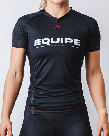 GB Essentials Women’s Ranked Rashguard in black, compression fit shown on model with EQUIPE wordmark and Gracie Barra detailing across the chest.