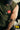Close-up of the army green sleeveless tech tee's left chest showing the rubberized Red Shield logo in contrast against the green fabric.