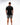 Flow Men's Tech Tee in black, full-length back view on a male model showing the small white Brazilian Jiu-Jitsu graphic on the upper back