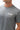 Flow Men's Tech Tee in dark grey, chest close-up showing the white Gracie Barra Stacked logo on the left chest and the crew neckline