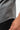 Flow Men's Tech Tee in dark grey, close-up of the curved hem and stitched side seam