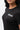 Flow Women's Tech Tee in black, chest close-up showing the white Gracie Barra Stacked logo on the left chest and the crew neckline