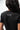 Flow Women's Tech Tee in black, back close-up showing the small white Brazilian Jiu-Jitsu graphic on the upper back