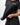 Flow Women's Tech Tee in black, upper-body view of a model pulling the hem out to show the stretch, white Gracie Barra Stacked logo on the left chest