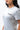 Flow Women's Tech Tee in light grey, angled upper-body close-up on a female model showing the dark Gracie Barra Stacked logo on the left chest