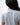 Flow Women's Tech Tee in light grey, back close-up showing the small dark Brazilian Jiu-Jitsu graphic on the upper back