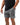 Frame Men's Short in dark grey, three-quarter front view with a hand in the side pocket and the white Gracie Barra Stacked logo on the lower left leg