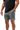 Frame Men's Short in dark grey, three-quarter front view with a hand in the side pocket and the white Gracie Barra Stacked logo on the lower left leg