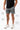 Frame Men's Short in dark grey, lower-body front view on a male model with the white Gracie Barra Stacked logo on the lower left leg