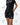 Frame Women's Short in black, three-quarter view on a female model, hand on hip, side hem vent and white Gracie Barra Stacked logo on the lower left leg