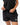 Frame Women's Short in black, front view with both hands adjusting the drawstring waistband, white Gracie Barra Stacked logo on the lower left leg