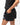 Frame Women's Short in black, side view with a hand in the side pocket and a side hem vent, white Gracie Barra Stacked logo on the lower left leg