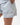 Frame Women's Short in light grey, lower-body close-up with a hand in the side pocket, side hem vent, white Gracie Barra Stacked logo on the lower left leg