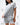 Frame Women's Short in light grey, mid-body three-quarter view with hands in pockets, side hem vent and white Gracie Barra Stacked logo on the lower left leg
