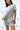 Frame Women's Short in light grey, mid-body three-quarter view with hands in pockets, side hem vent and white Gracie Barra Stacked logo on the lower left leg