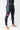 Angled view of model in black GB Essentials compression pants with the red Gracie Barra triangle logo on the left thigh