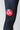 Close-up of the red and white Gracie Barra circular logo patch on the thigh of the black GB Essentials compression pants