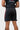 Back view of the black GB Essentials Mens Velcro Training Shorts showing both side panels, the red BARRA print and the split hems.
