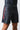 Angled side view of black GB Essentials Velcro Training Shorts on model with red Gracie side print and leg vent