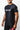 Man wearing the black GB Essentials Mesh Training Tee, three-quarter view highlighting the red side piping and GB sleeve logo