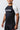 Angled three-quarter view of a male model wearing the GB Essentials Ranked Rashguard, showing the Gracie Barra sleeve print and patterned side panel