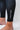 Ankle cuff of the black GB Essentials Womens Compression Pants with a white vertical EQUIPE wordmark and circled GB logo above the hem.