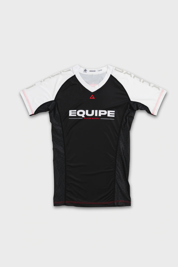 Front view of the GB Essentials Womens Ranked Rashguard in white, with a black body, white shoulder panels and EQUIPE printed across the chest, laid flat