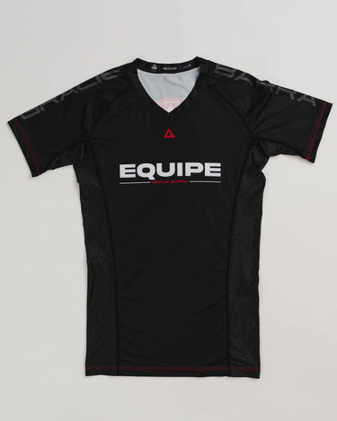 GB Essentials Women’s Ranked Rashguard in black with short sleeves, Gracie Barra Equipe branding, and red stitching accents, laid flat on a white background.