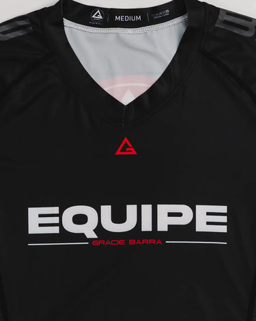 Close-up of GB Essentials Women’s Ranked Rashguard in black, showing Legacy G logo and sweat-wicking stretch fabric.