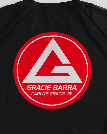GB Essentials Women’s Ranked Rashguard in black, close-up of Gracie Barra Red Shield logo with ‘Carlos Gracie Jr.’ text on the back.
