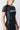 Close-up angled view of the black GB Essentials Womens Ranked Rashguard highlighting the geometric patterned side panel, red trim and tonal Gracie Barra shoulder print