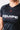 Close-up of the chest on the black GB Essentials Womens Ranked Rashguard showing the V-neck, red Gracie Barra triangle logo and white EQUIPE Gracie Barra print