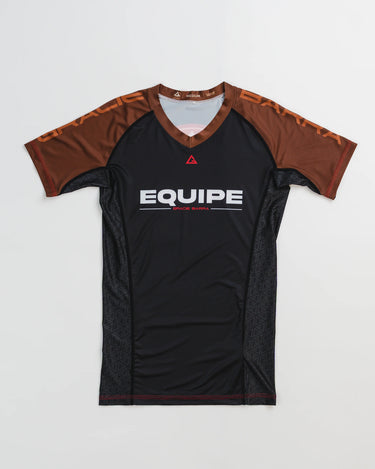 GB Essentials Women’s Ranked Rashguard in black with brown sleeves, featuring ‘Equipe Gracie Barra’ branding on the chest and split stacked logo on shoulders.