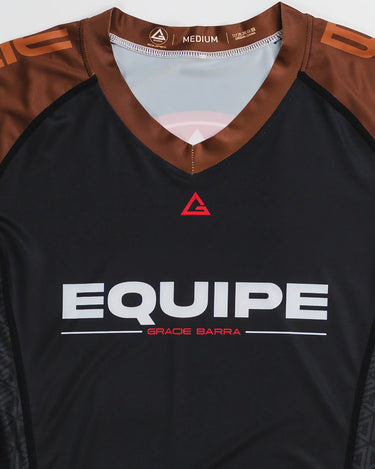 GB Essentials Women’s Ranked Rashguard in black with brown shoulders, featuring the Equipe Gracie Barra wordmark across the chest and red Legacy G logo at the collar.