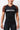 Front view of a woman wearing the black GB Essentials Womens Ranked Rashguard with brown sleeves, showing the white Equipe Gracie Barra logo across the chest.