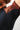 Fabric close-up of the GB Essentials Womens Ranked Rashguard, showing the brown sleeve with red stitching meeting the triangle-textured black panel and seamless underarm construction.
