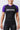 Woman wearing the GB Essentials Womens Ranked Rashguard in purple, front view showing white EQUIPE Gracie Barra chest print and purple raglan sleeves