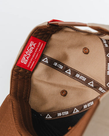 Inside view of the GB Trademark Cap showing the red woven label and black taping printed with Jiu-Jitsu and Legacy G logos, photographed on a white background.