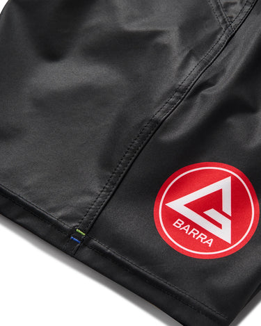 Detail of red Barra Shield logo on left leg of black Gracie Barra x Vanguard Evolution No Gi Shorts with reinforced stitching.