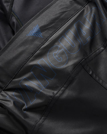 Close-up of tonal blue “Vanguard” branding and triangle logo detail on black Gracie Barra x Vanguard Evolution No Gi Shorts.