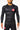 Athlete wearing black Gracie Barra x Vanguard Evolution rashguard with red Barra Shield chest logo, yellow “Equipe” shoulder detail, and matching GB shorts.