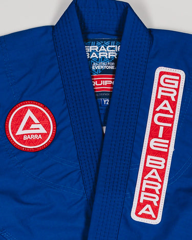 Close-up of Red Shield patch and Gracie Barra chest patch on the blue kids’ kimono.