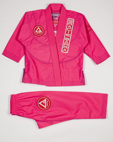 Pink GBK Lite Ripstop kids’ kimono set with Red Shield patches, a Gracie Barra lapel patch, and a GB label at the bottom of the lapel. Jacket and pants are shown clearly to help parents see the fit, color, and details perfect for young girls starting their Jiu-Jitsu journey.