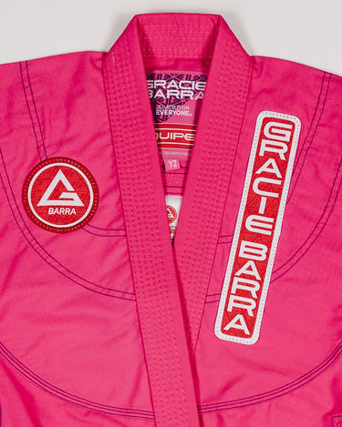 Close-up of the pink GBK Lite Ripstop kimono showing the Red Shield chest patch, the Gracie Barra lapel patch, and reinforced collar stitching—details parents appreciate for comfort and durability.