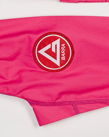 Close-up of the Red Shield patch on the pants of the pink GBK Lite Ripstop kimono, showing the strong stitching and soft, flexible fabric parents look for in active kids’ gear.