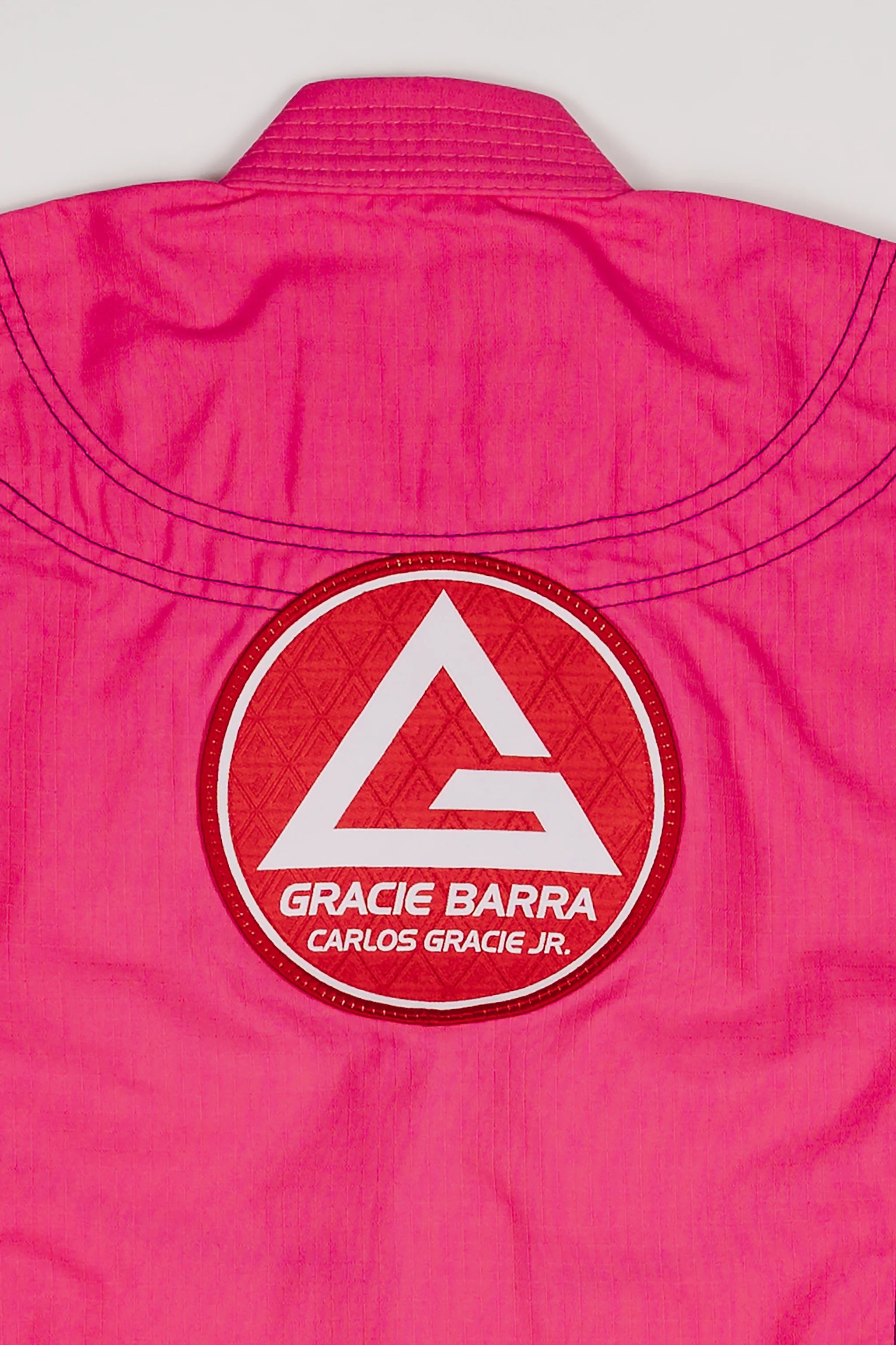 Close-up of the large Red Shield patch on the back of the pink GBK Lite Ripstop kimono, highlighting the sturdy stitching and bright color parents appreciate for long-lasting wear.
