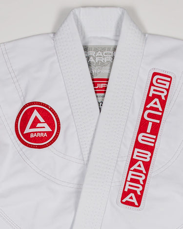 Close-up of Red Shield patch and Gracie Barra vertical patch on the white kids’ kimono.